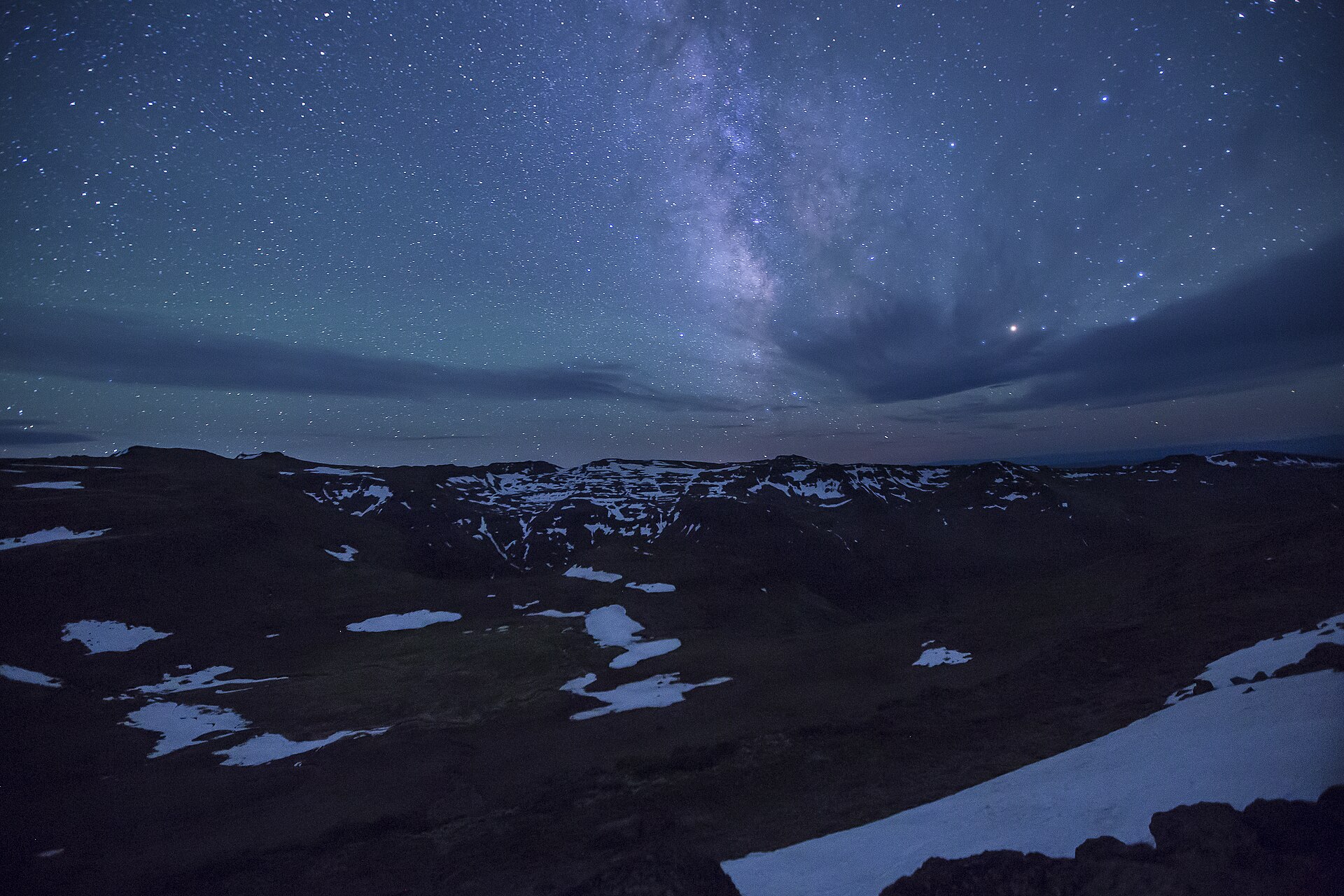 The Milky Way rising over snow-patched high-desert mountains